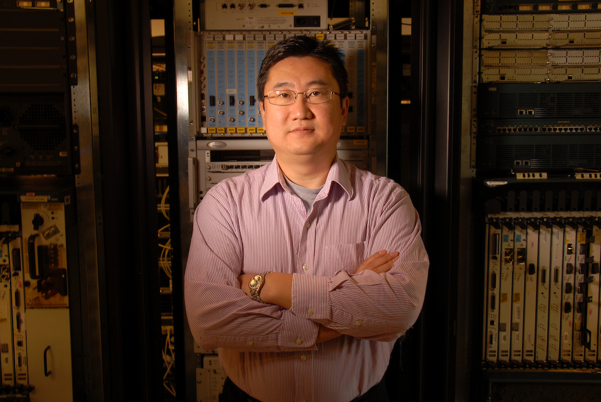 Researcher standing in front of computer server in lab
