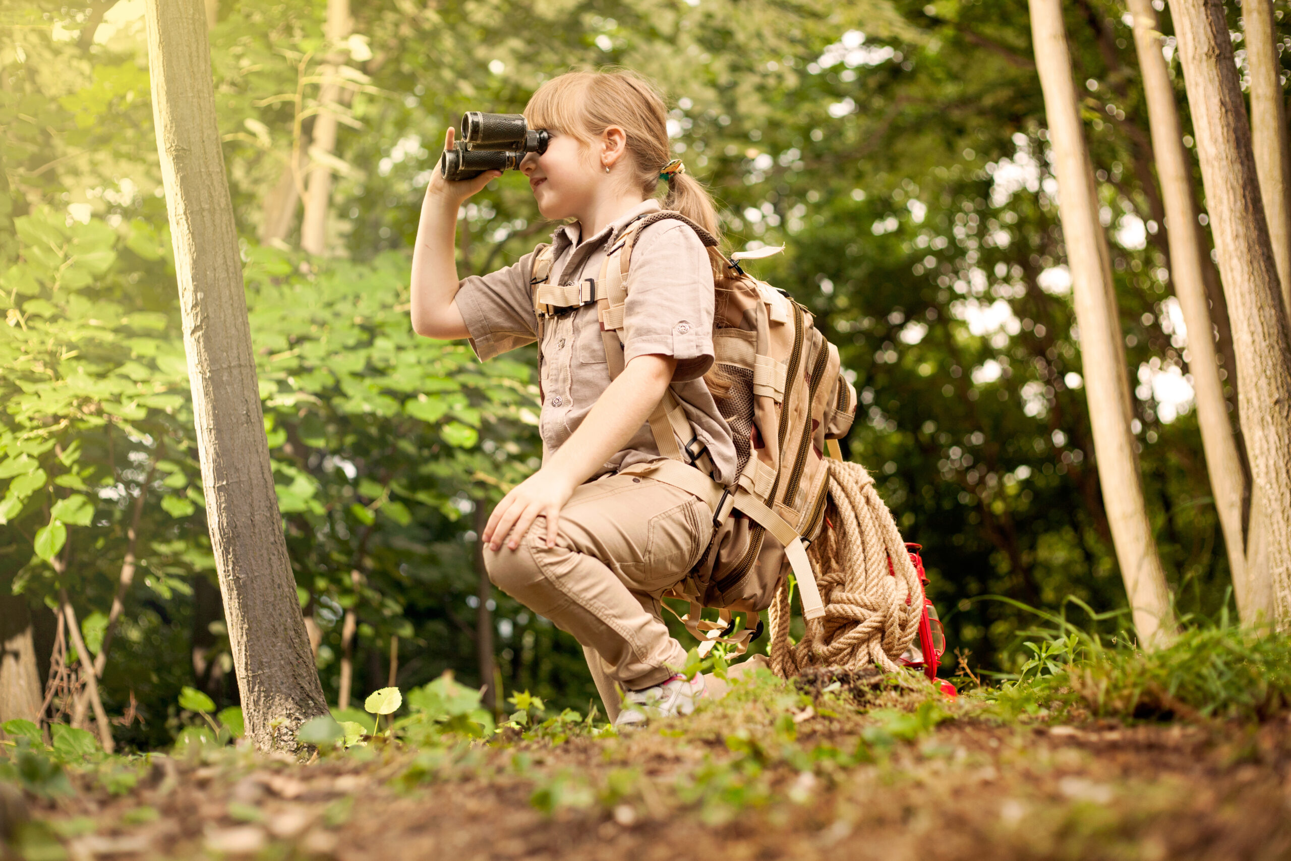 girl go hiking with backpacks on a forest road bright sunny day