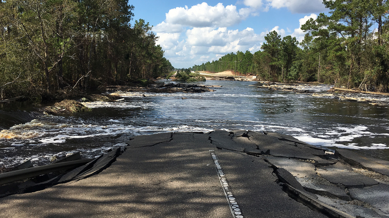 A cracked highway disappears into flood waters.