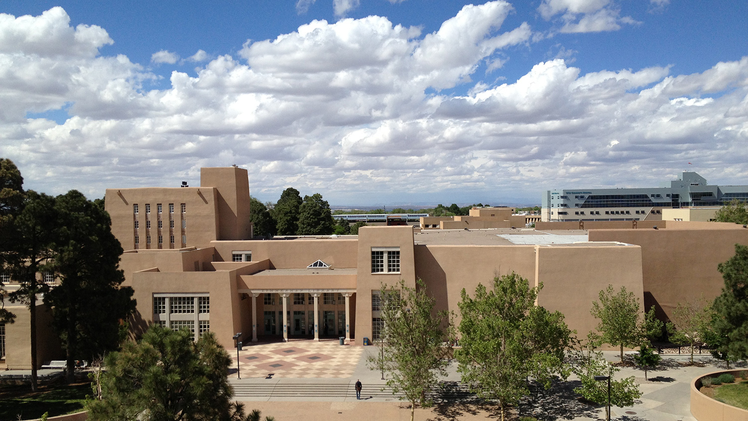 The University of New Mexico's campus against a blue sky.