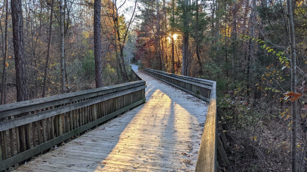 A wooden bridge at sunset in fall.