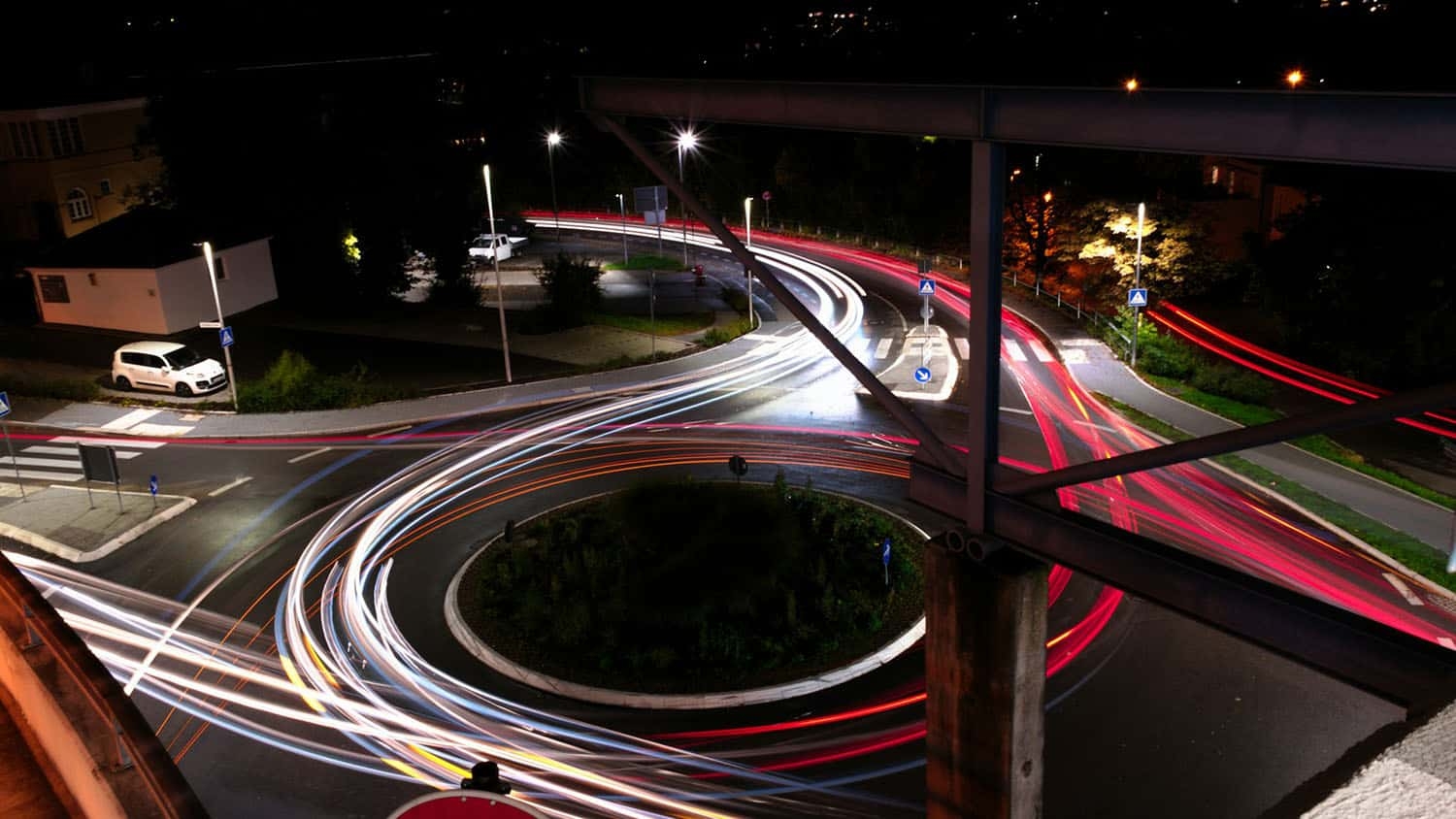 time lapse photograph shows traffic going through a roundabout at night