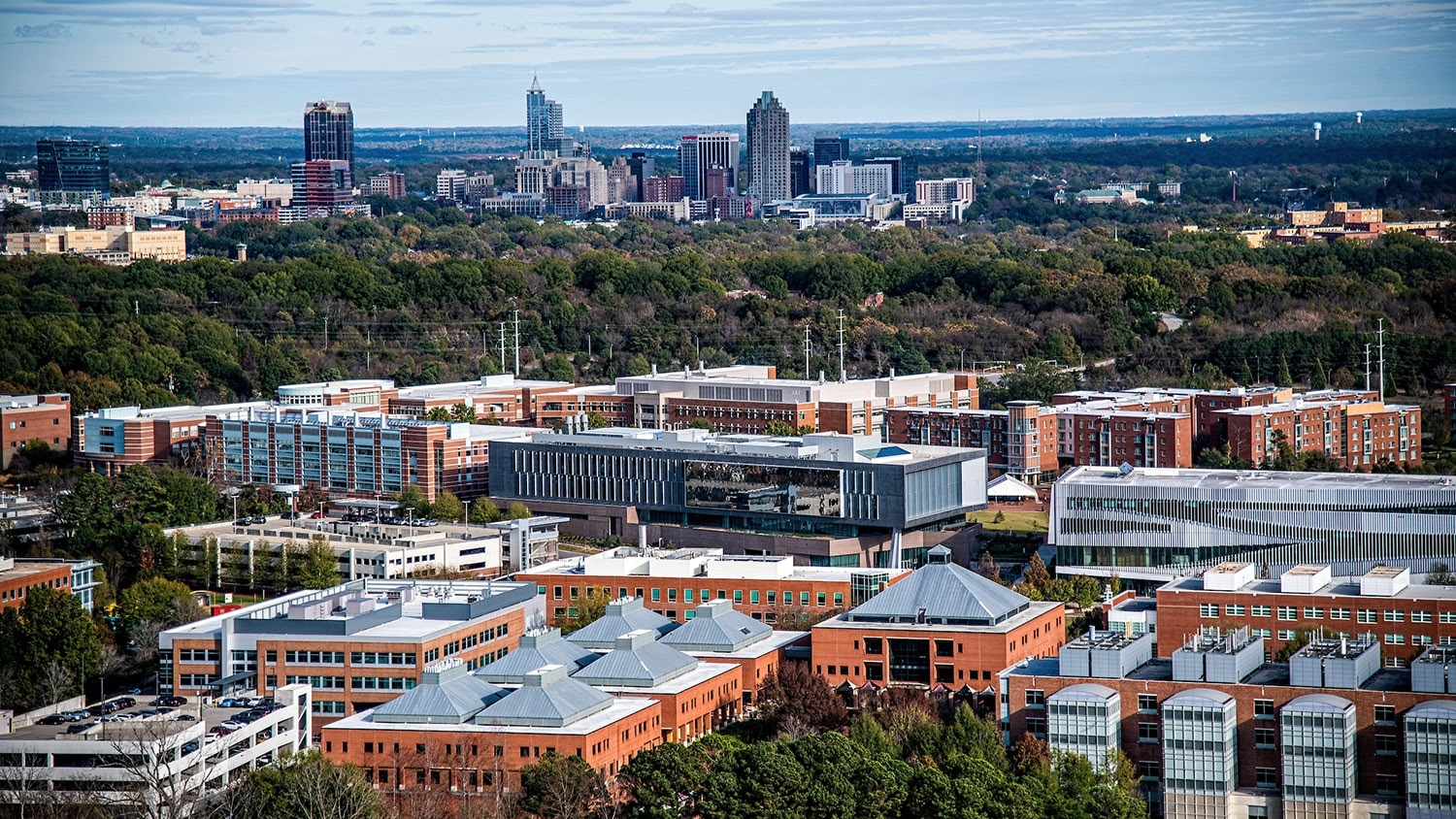 An aerial photo of NC State's Centennial Campus with the Raleigh skyline behind it.