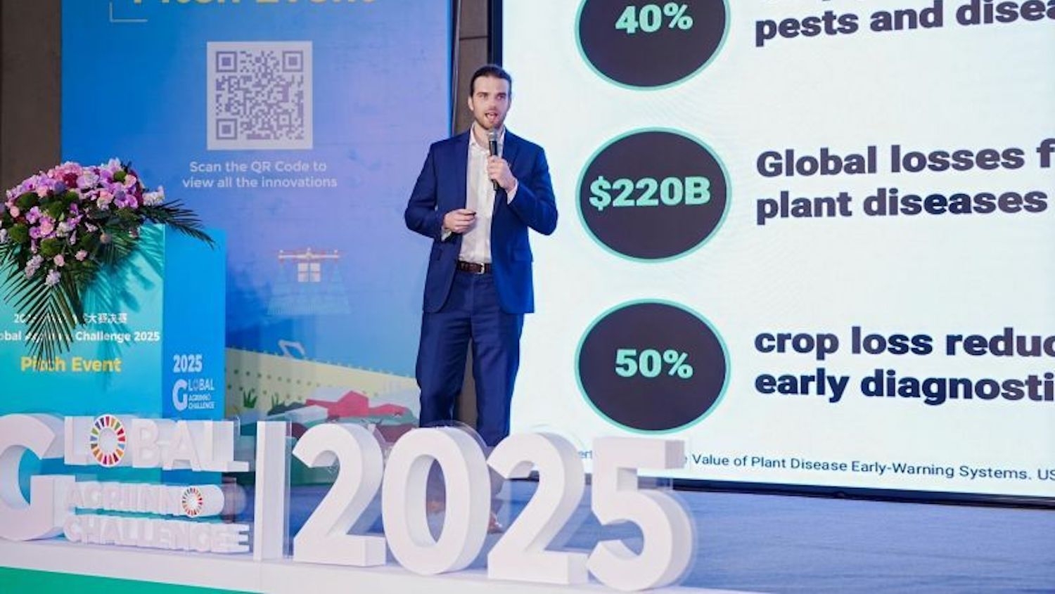 Man on a stage presenting a talk about plant protection.